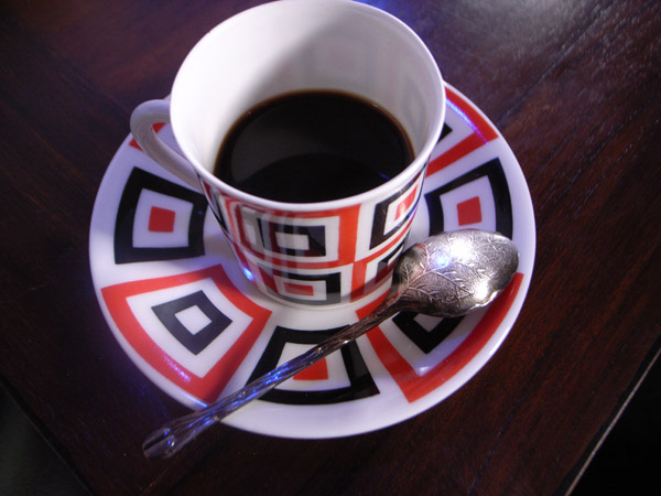 Café y cucharilla de café con grano germinando